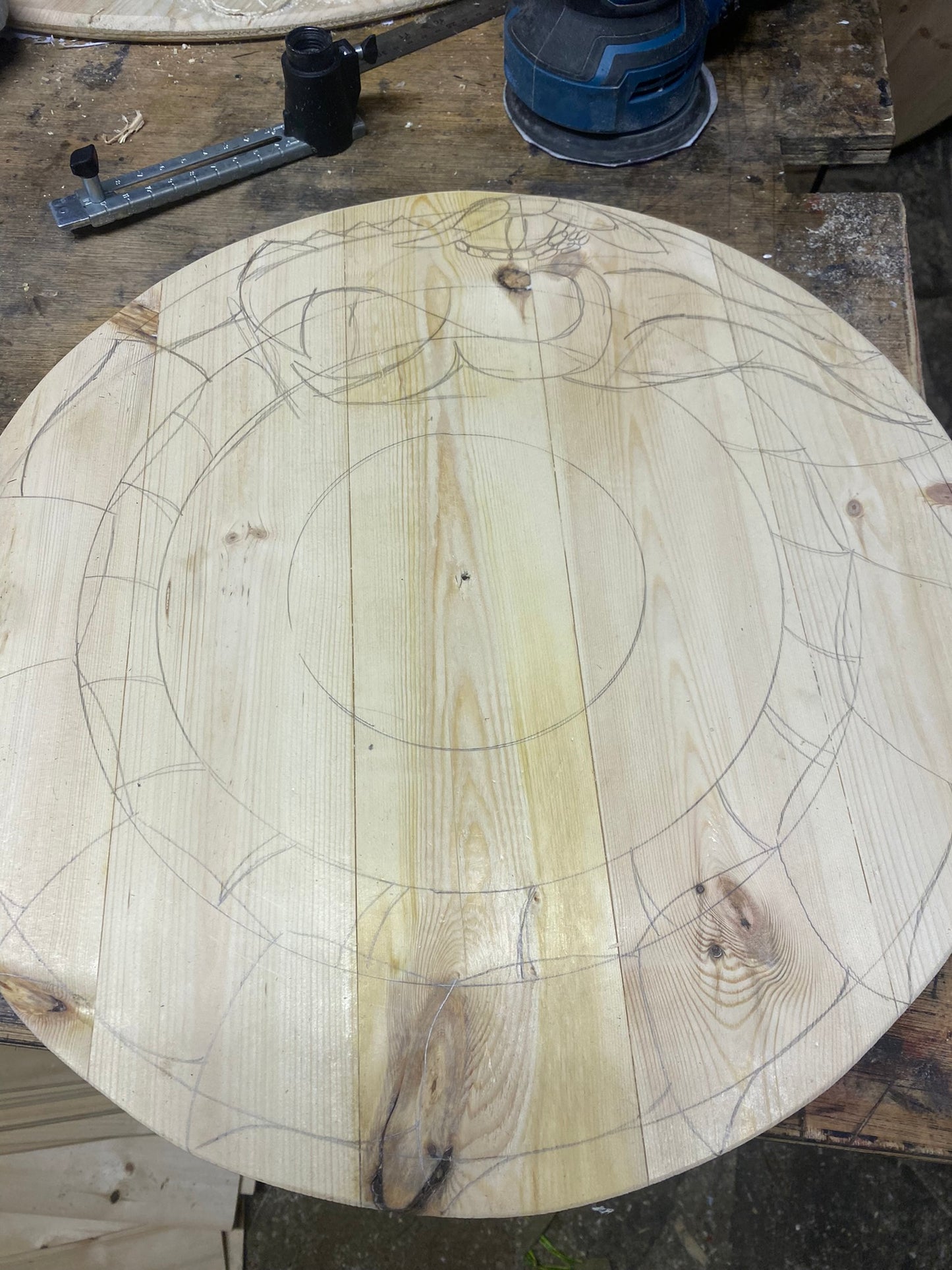 Progress images of a hand drawn and carved customer shield