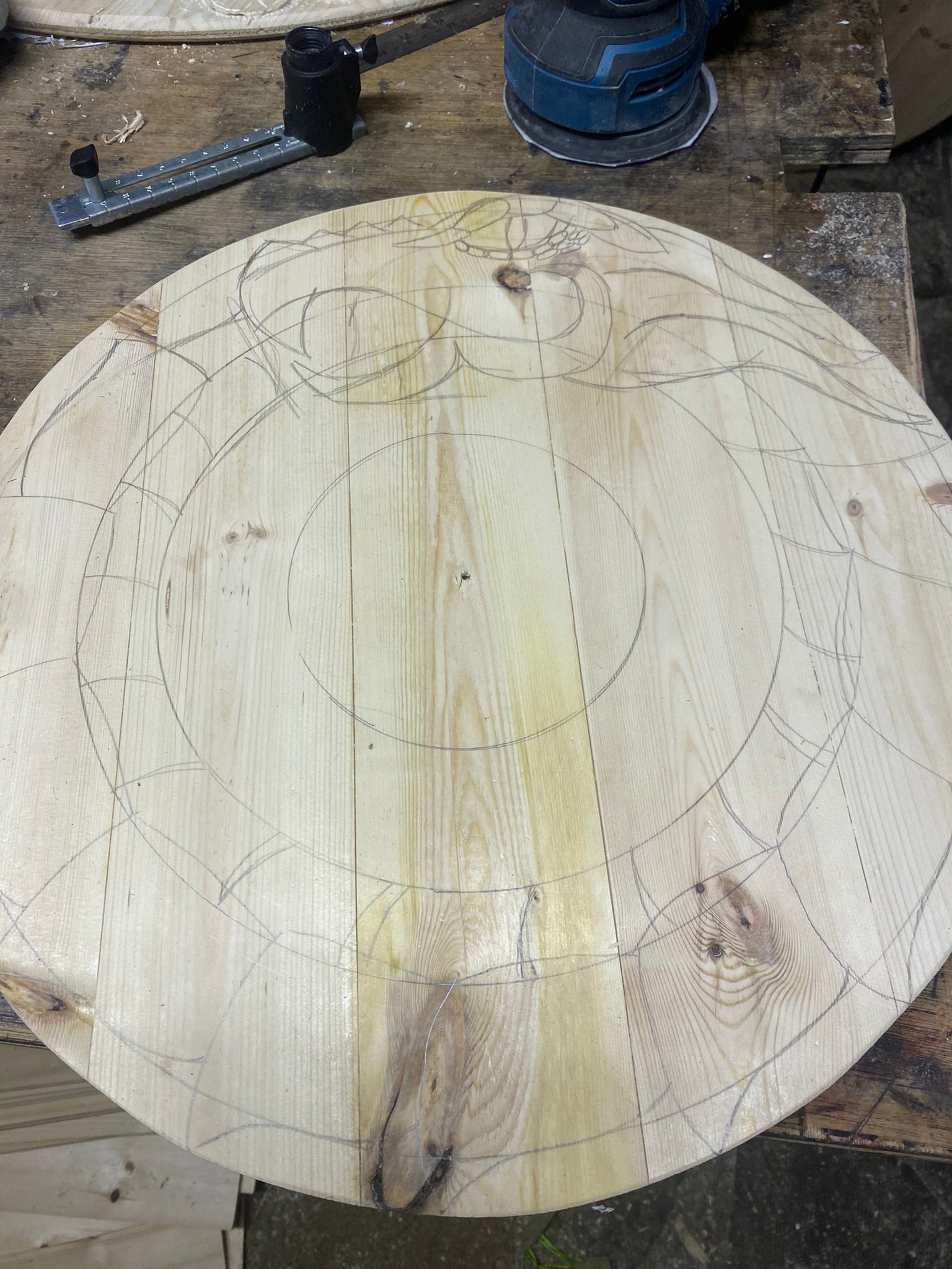 Progress images of a hand drawn and carved customer shield