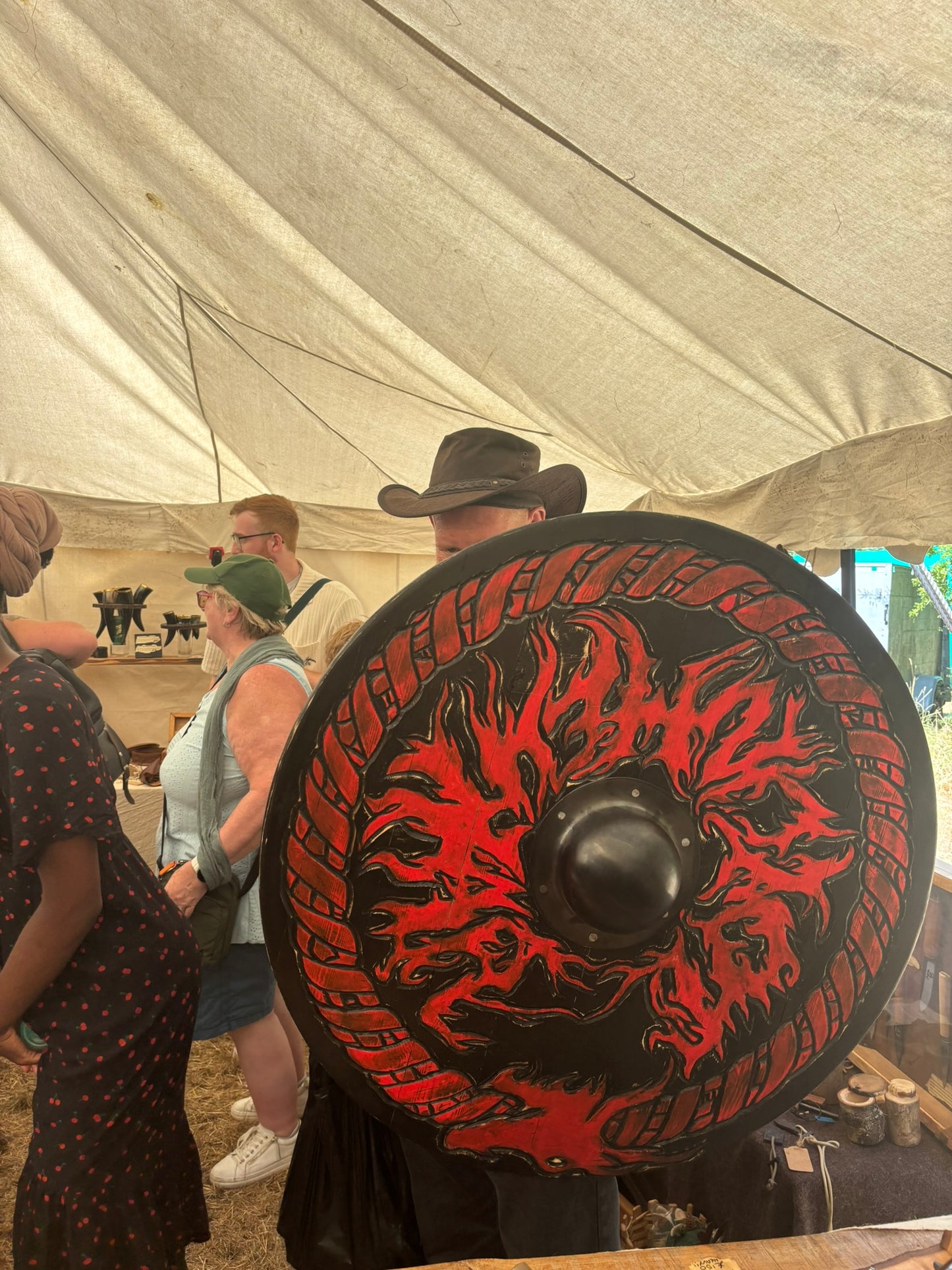A large round medieval-style shield with a red and black dragon design, made for Jötunheimar, a Viking Metal Band from he UK