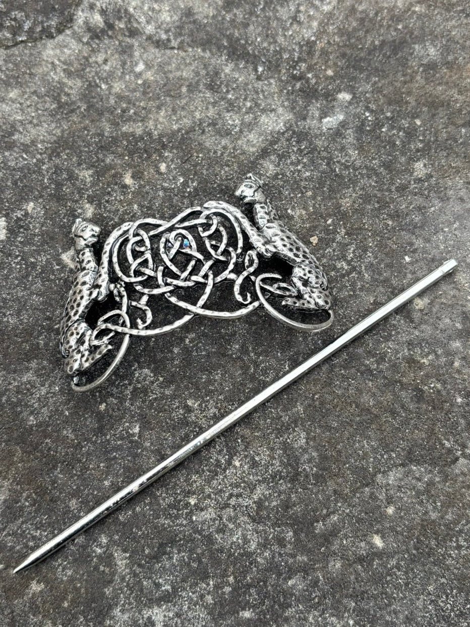 An antique Freya's Hair Slide — Antique Silver with a matching slender pin, displayed on a textured gray stone surface.